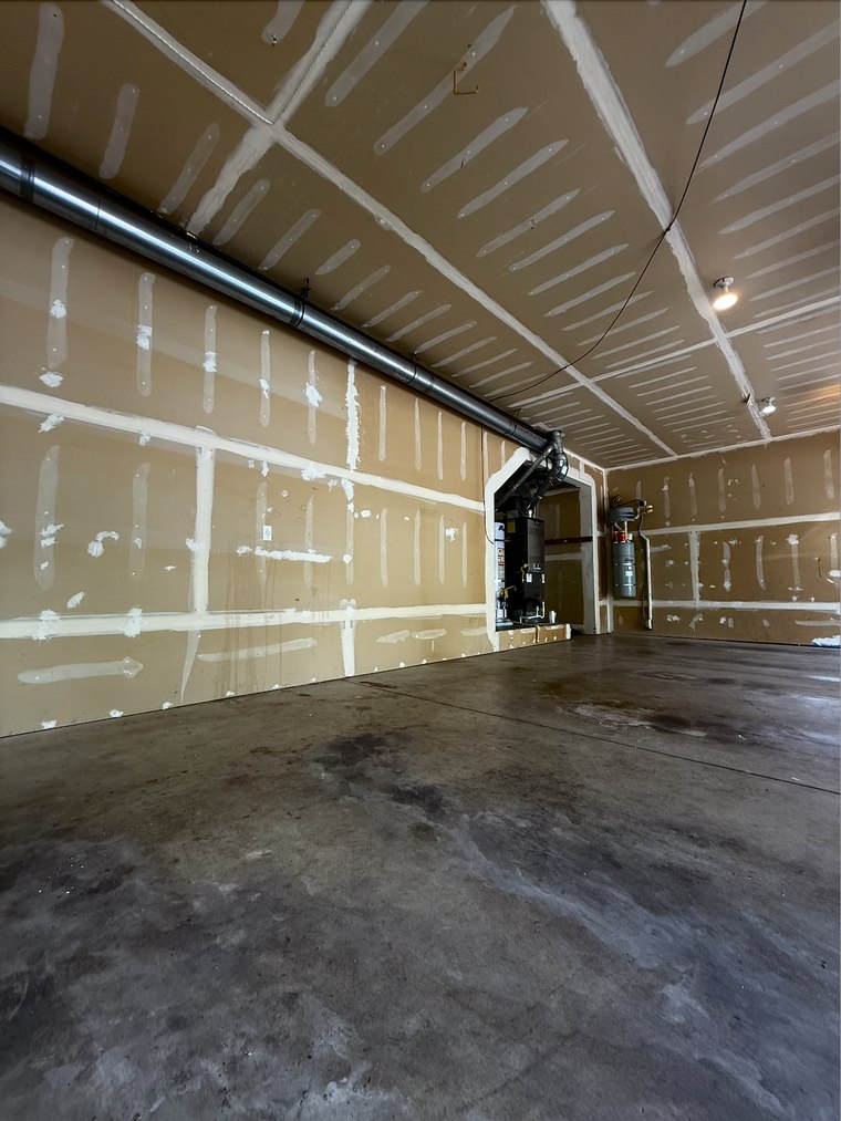 Before: unfinished garage with taped drywall and bare concrete floor, Greater Seattle Area